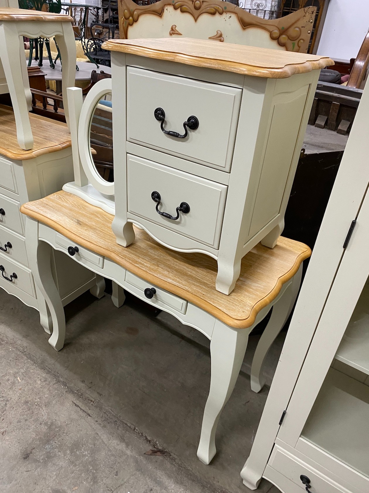 An oak and eau de nil painted wood six piecebedroom suite, from 'Oak Furniture Land' comprising a chest of drawers, dressing table and stool, a mirror and two bedside chests